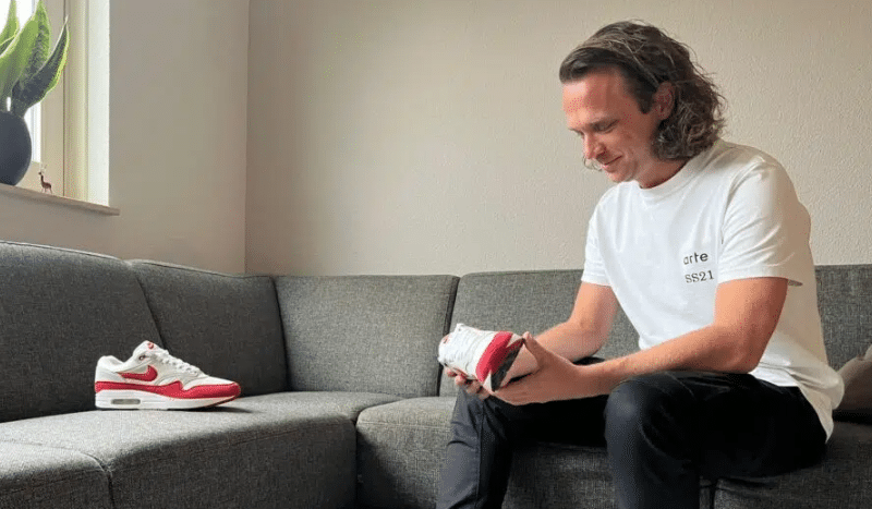 Roel Driessen zittend op de bank met een paar Nike Air Max 1 ’86 Big Bubble Sport Red in zijn hand.