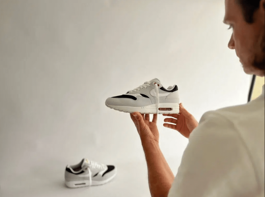 Roel Driessen, staand voor een fotodoek met een paar Nike Air Max 1 Urawa in zijn hand